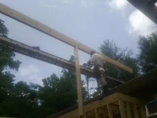 Carpenter setting a ridge beam over a new addition frame — Ice Dam Removal by Roofing Brothers in Pekin