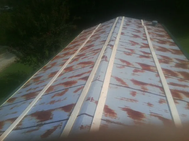 Rusted metal roof panels with new wood purlins before replacement — Storm Damage Roof Repair in Pekin by Roofing Brothers